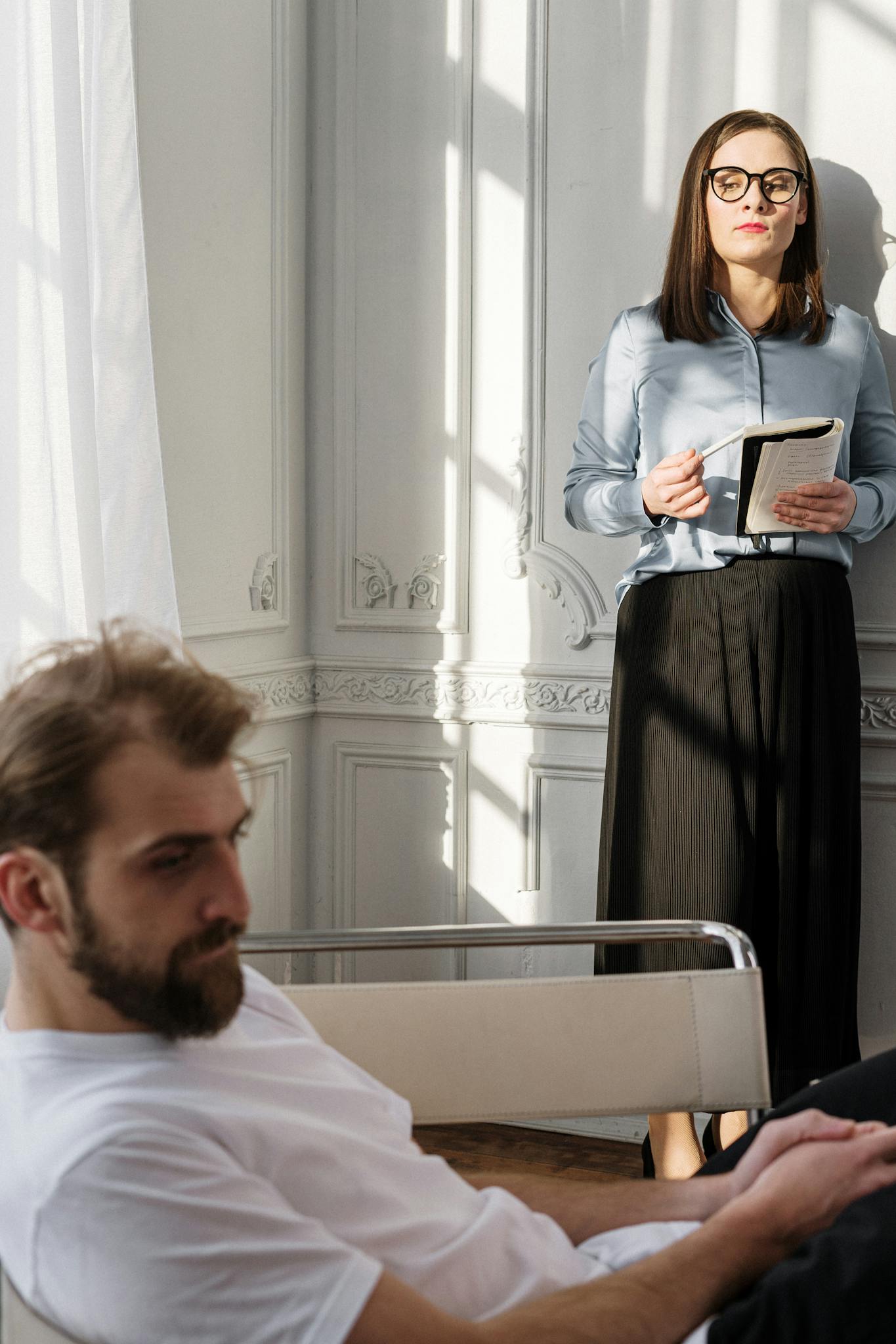 A therapist and patient in a reflective indoor session, facing emotional challenges.